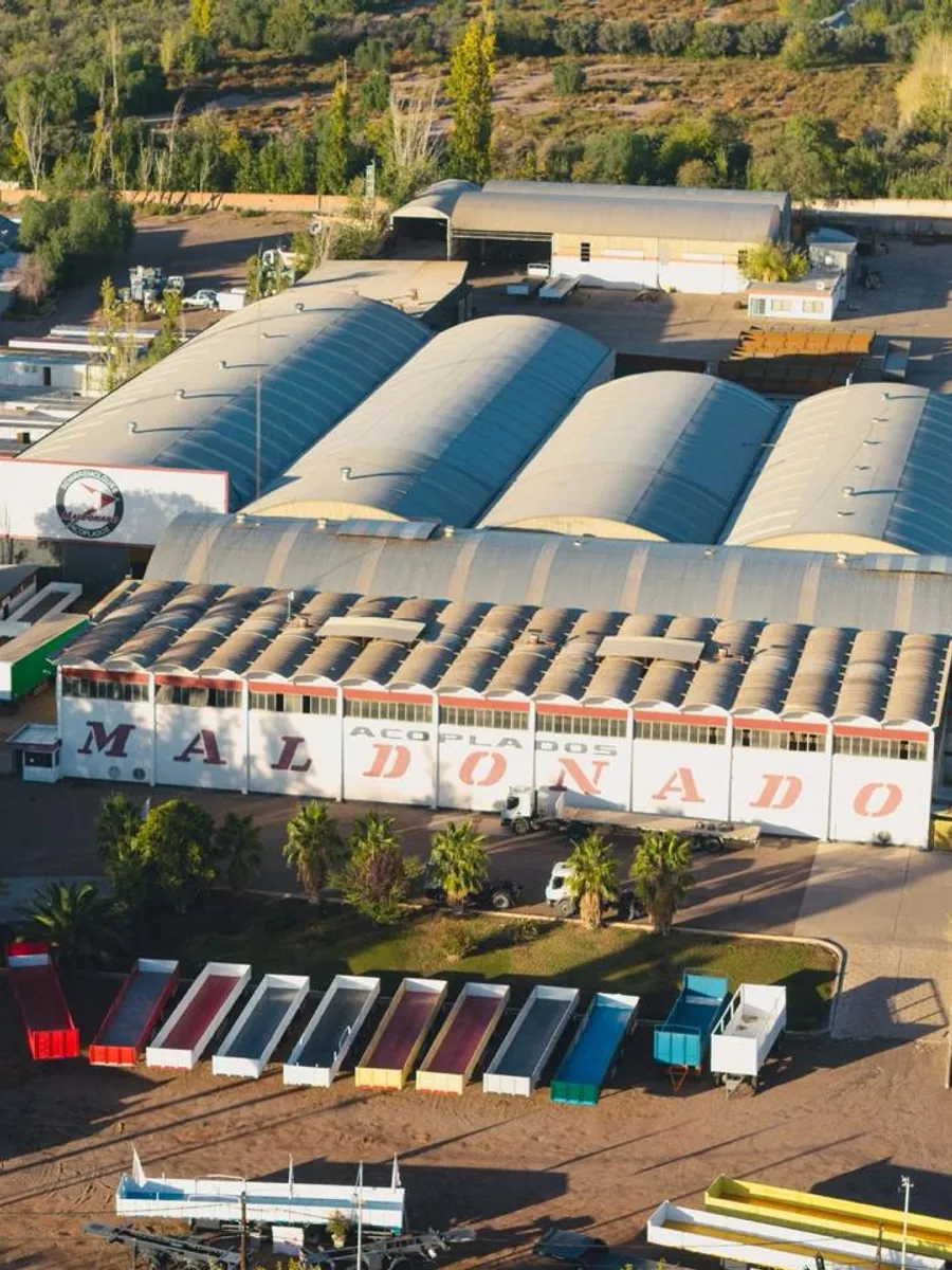 Vista aérea de la planta Maldonado en Mendoza: las naves con el cartel MALDONADO ACOPLADOS y la playa con la fila de unidades terminadas.